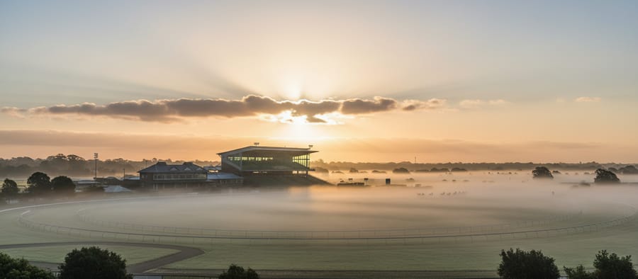 A racecourse under a hazy sunrise